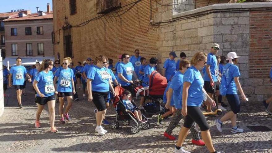 Participantes en la carrera solidaria visten las camisetas azules durante su recorrido por las calles de Toro.