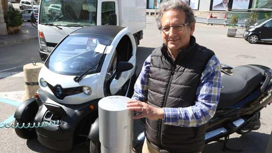 Todd Kolod en el punto de carga de Vara de Rey con su ´scooter´ eléctrica y un Twizy de Renault de otro propietario