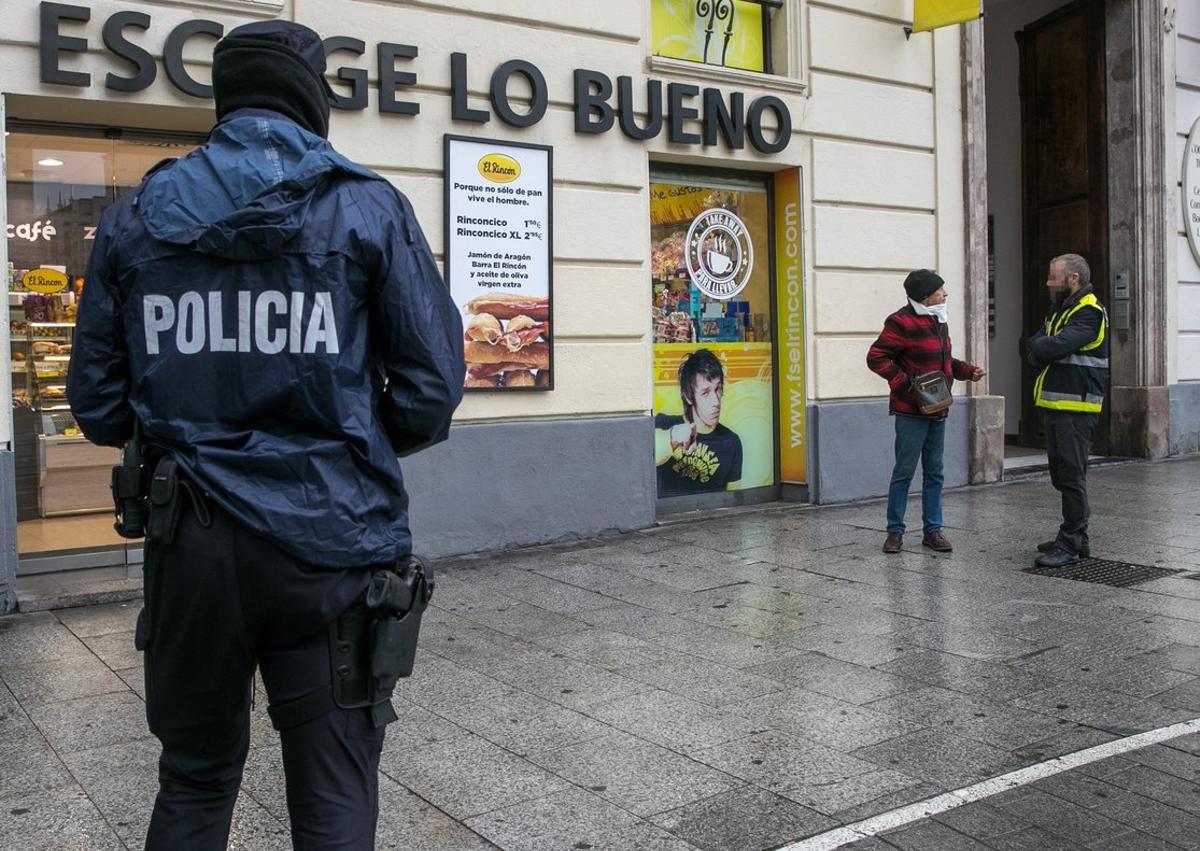 GRAF7598. ZARAGOZA, 16/03/2020.- Un policía pregunta a un hombre sobre el motivo de su estancia en la calle. Las Fuerzas de Seguridad han impuesto 42 sanciones en Zaragoza y 3 en Huesca por incumplimientos de las medidas de confinamiento. Aragón, al igual que el resto de España, vive este lunes su primer día laboral de aplicación del decreto de alarma, que supone entre otras medidas la restricción de la movilidad. EFE/Javier Cebollada