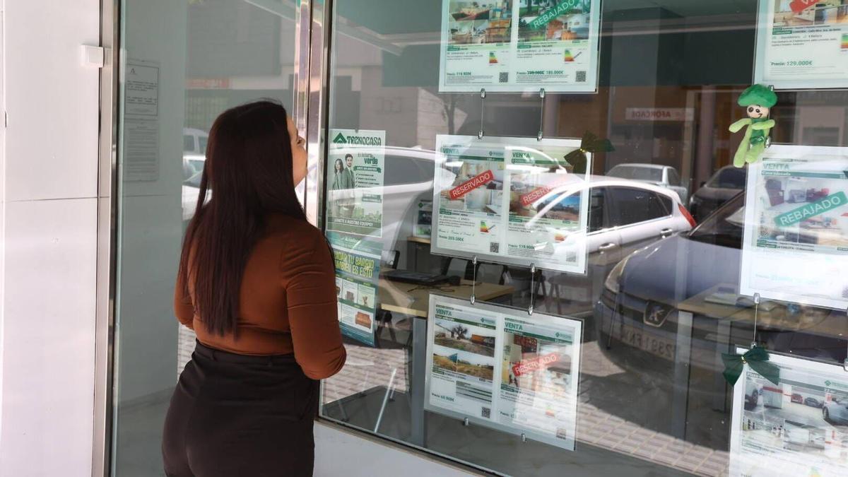 Una mujer observa los precios de una inmobiliaria cordobesa.