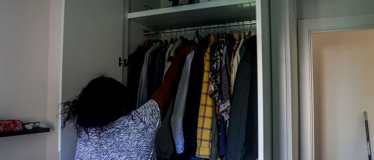 Una empleada del hogar ordena un armario en la vivienda en la que trabaja.