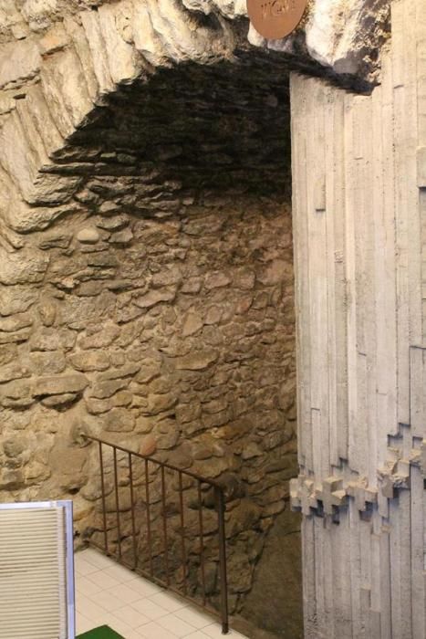L'interior de l'establiment del número 4 de la Pujada de les Pedreres, on hi ha una escala que baixa cap al subsòl i el que podria ser un arc tapiat