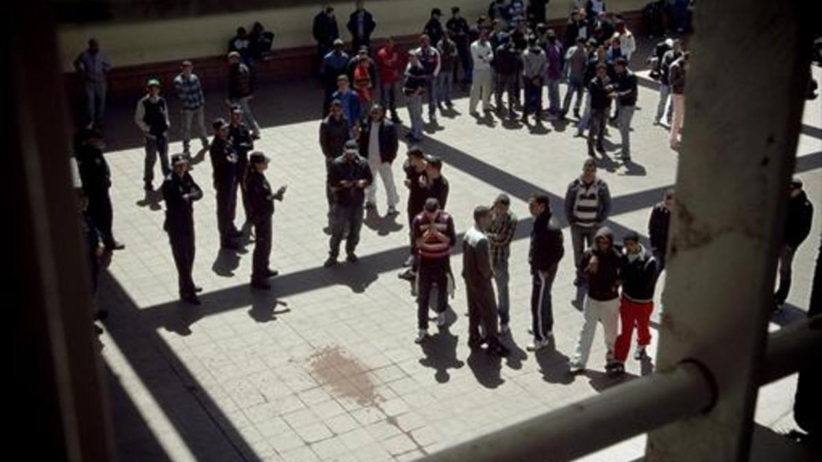 Policías e inmigrantes recluidos en el CIE de la Zona Franca, en el patio del centro.