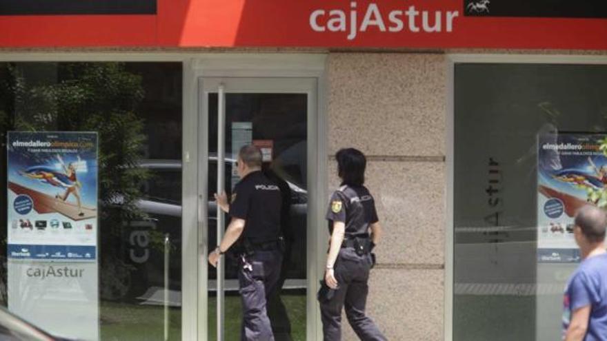 Agentes de Policía, a la puerta de la sucursal asaltada durante la mañana de ayer.