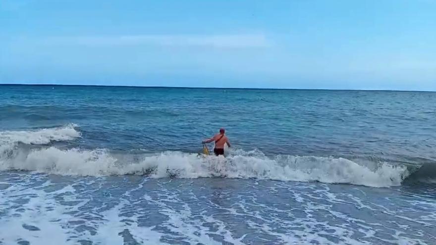 Un policía local rescata a un bañista en la playa del Bol Nou