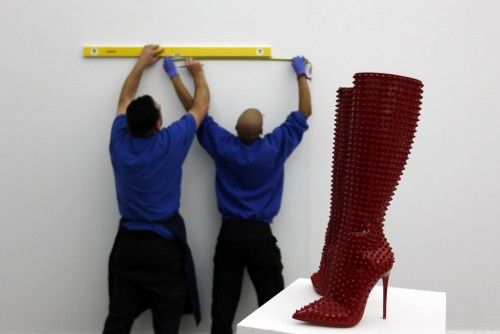 Sotheby's employees work behind Louboutin boots at Sotheby's auction house in London