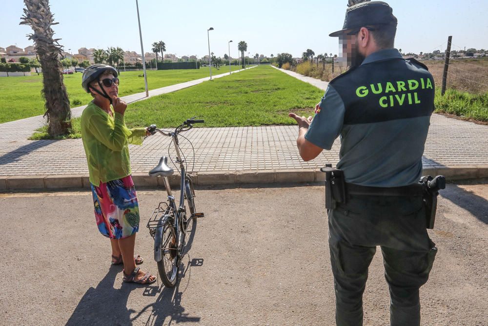 Guardia Civil y Policía cierran el paso a los bañistas en la laguna de Torrevieja. El personal del parque natural y agentes ambientales de la Generalitat informan sobre la prohibición de baño