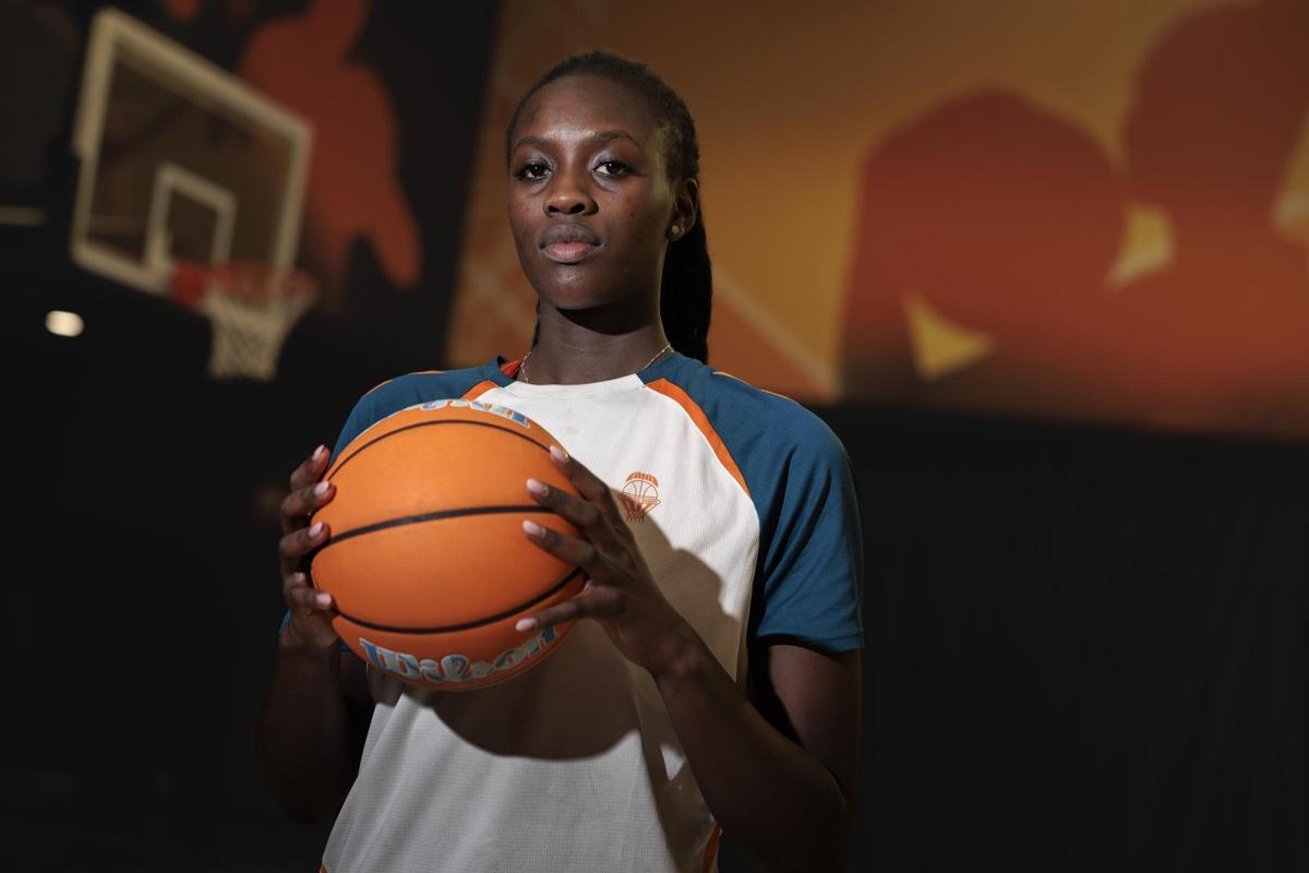 Awa Fam posa con un balón de baloncesto para una sesión fotográfica
