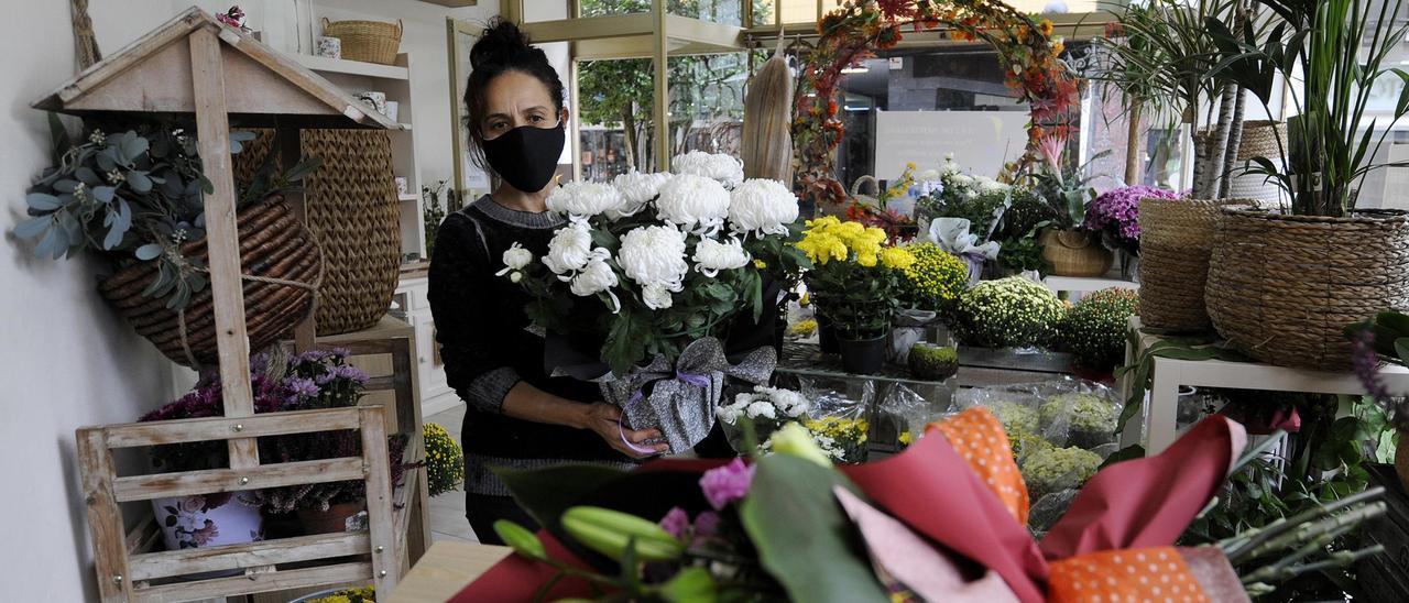 Luz González, con varias plantas y flores típicas de estas fechas.