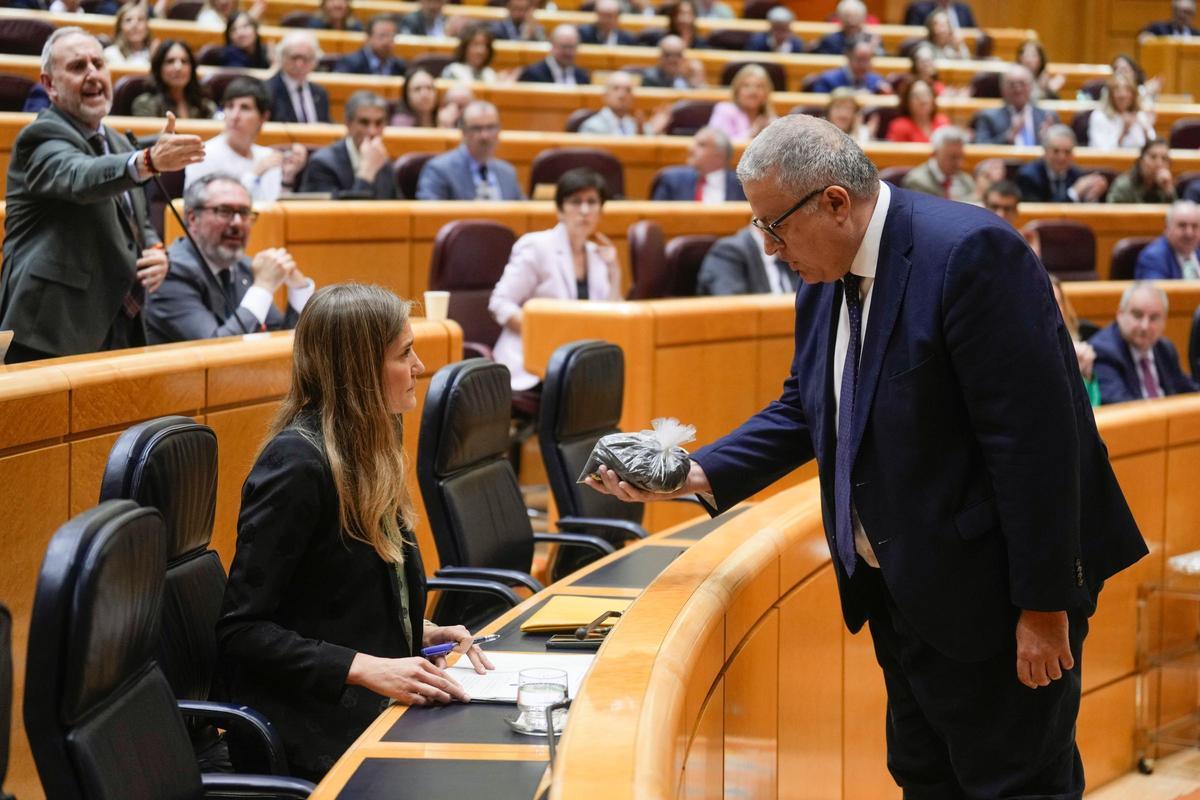 Francisco Bernabé, senador del PP, hace entrega de una bolsa con arena tóxica a la vicepresidenta tercera, Sara Aagesen.