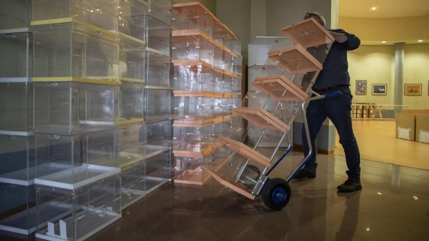 Un operario colocando urnas en unos anteriores comicios.