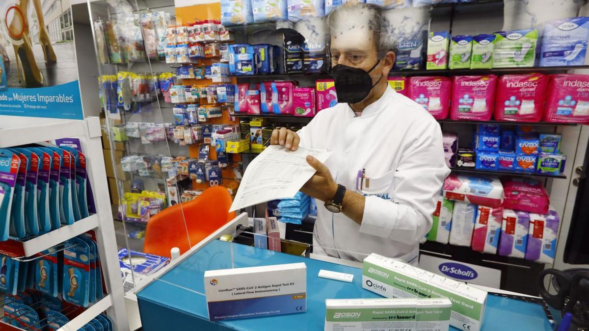 Manuel Arribas, de la farmacia Artal de Zaragoza, junto a varios tipos de test de antígenos.  | JAIME GALINDO