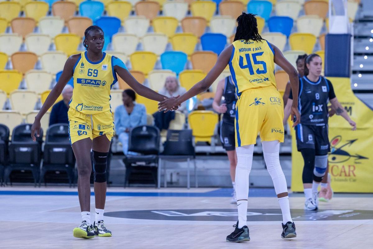 Adji Fall (i.) y Astou Ndour se chocan la mano durante el partido de ayer en el Gran Canaria Arena. | | CB ISLAS CANARIAS