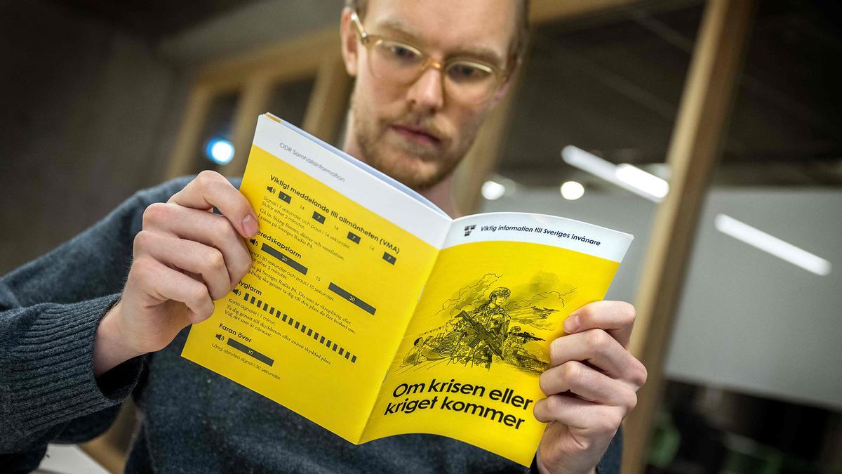 Un hombre lee el manual 'Si llega la crisis o la guerra'.