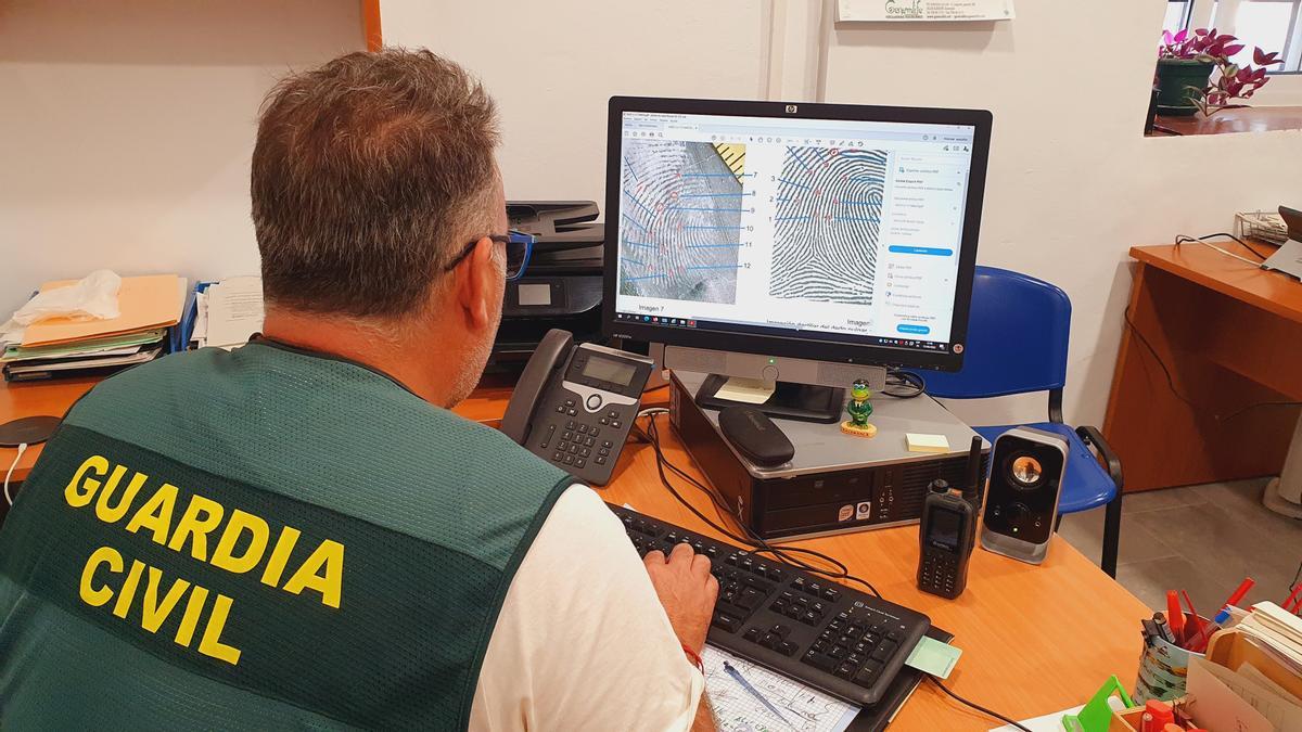 Un guardia civil coteja las huellas conseguidas.