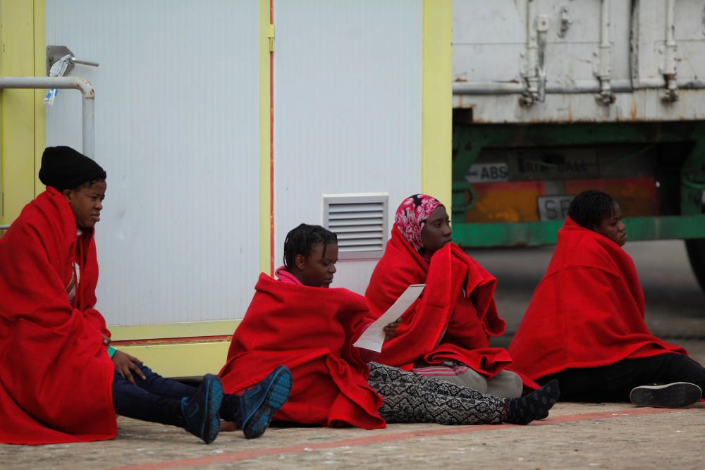 Migrants rest upon arriving on a rescue boat at ...