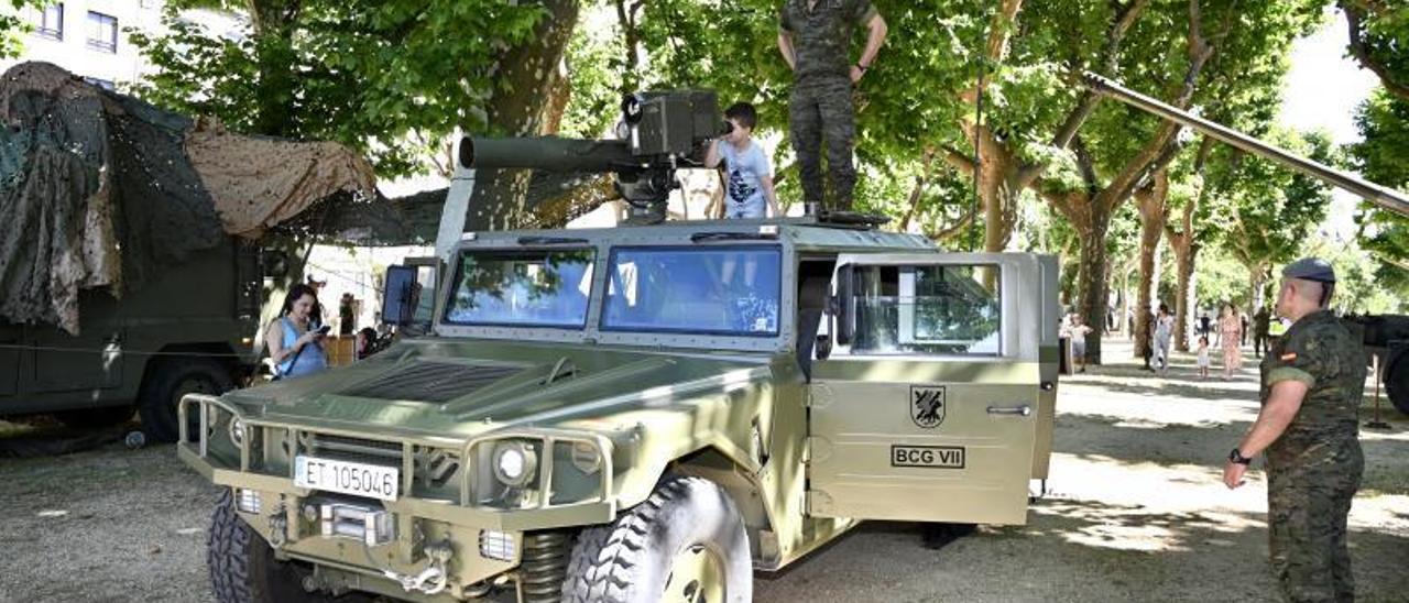 Un niño acompañado de un militar subido a un vehículo Vamtac.   | // RAFA VÁZQUEZ