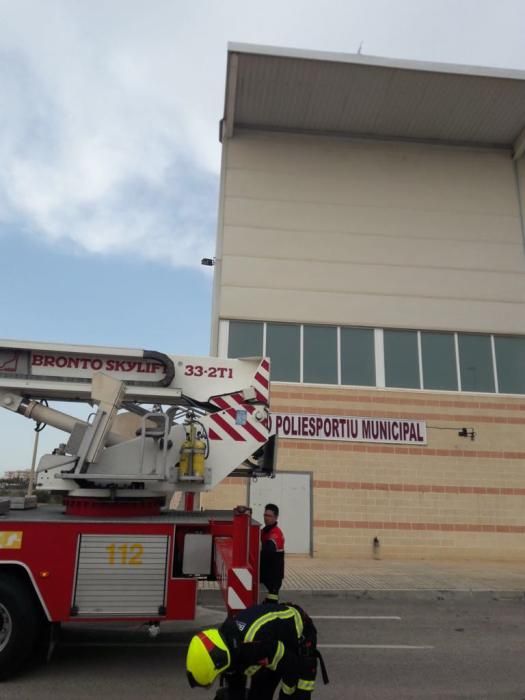 Los bomberos en el Polideportivo de Santa Pola, donde parte de la cubierta se ha caído por el fuerte viento