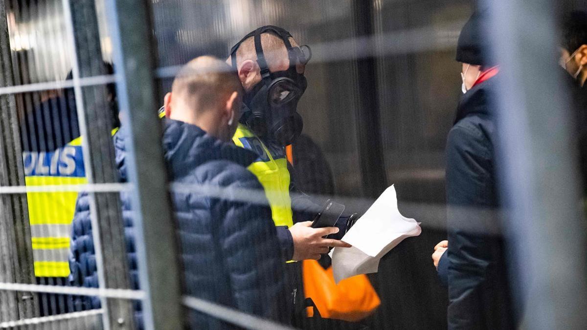 Viajeros procedentes de Dinamarca pasan un control de la policía suiza (con máscaras protectoras) en el puesto fronterizo de la estación de Hyllie, este martes