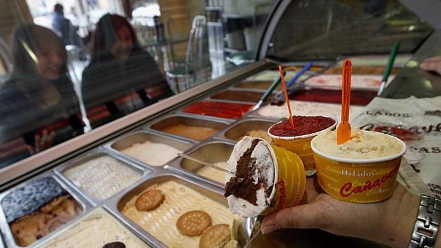 Dos clientas observan la gran variedad de sabores existente en una heladería alicantina.