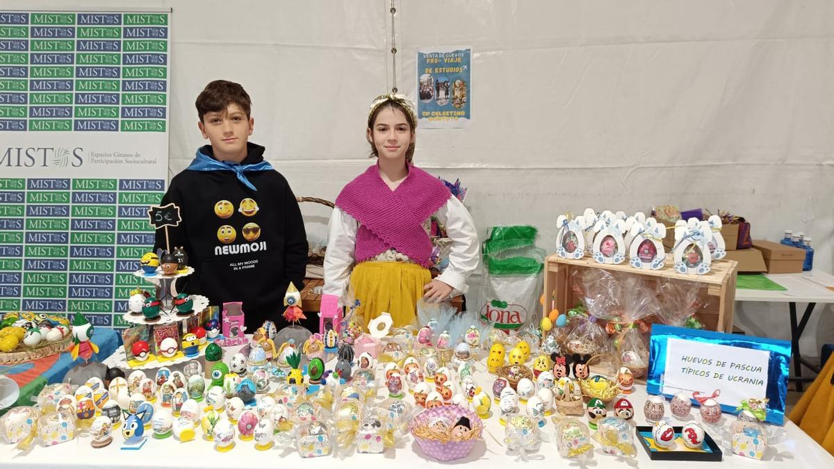 Rodrigo Nava y Olivia Villa, alumnos del colegio Celestino Montoto de Pola de Siero, en el puesto del mercáu.
