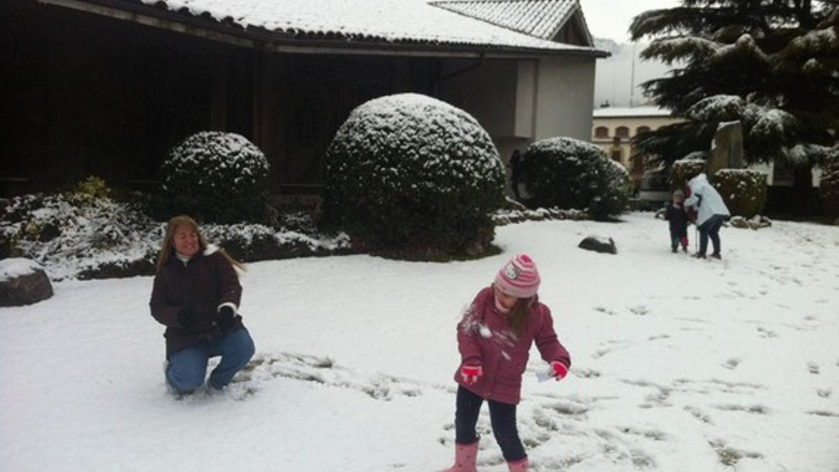 Una niña y su madre juegan con la nieve en su casa de Aiguafreda.