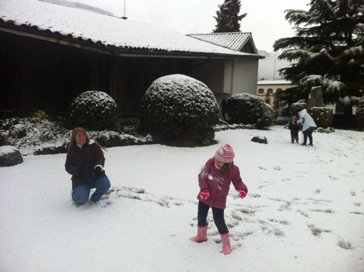 Una nena i la seva mare juguen amb la neu a casa seva, a Aiguafreda.