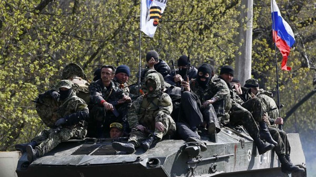 Hombres armados con el símbolo negro y naranja característicos de las tropas prorrusas, a bordo de un tanque con la bandera rusa, este miércoles en Slaviansk.