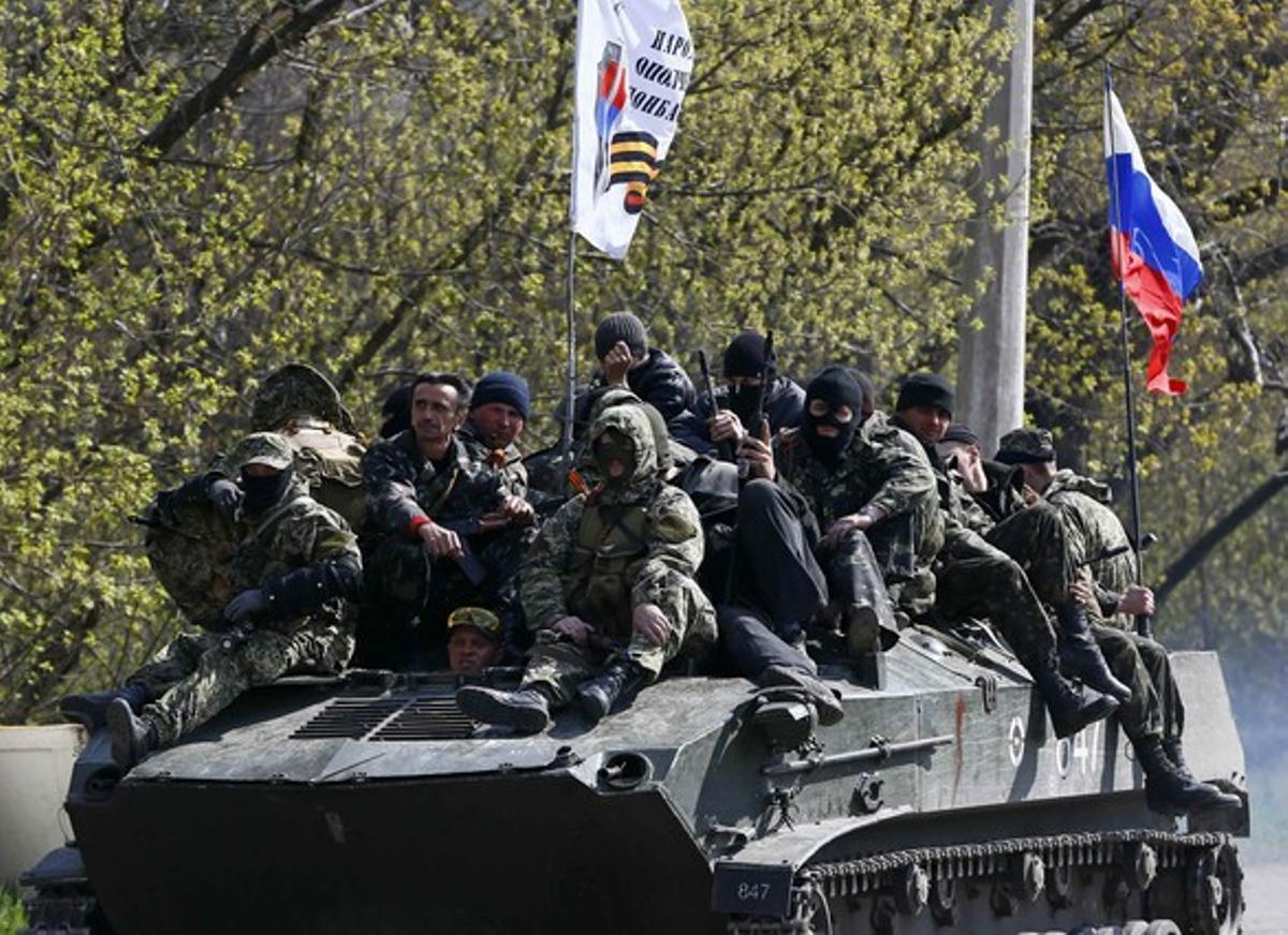 Homes armats amb el símbol negre i taronja característics de les tropes prorusses, a bord d’un tanc amb la bandera russa, aquest dimecres a Slaviansk.