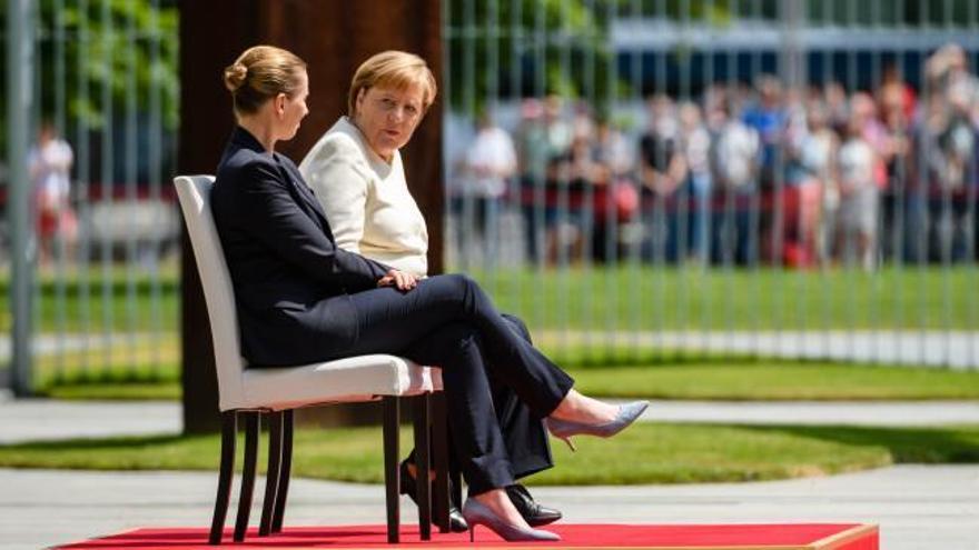 Angela Merkel escucha el himno nacional sentada tras varios episodios de temblores