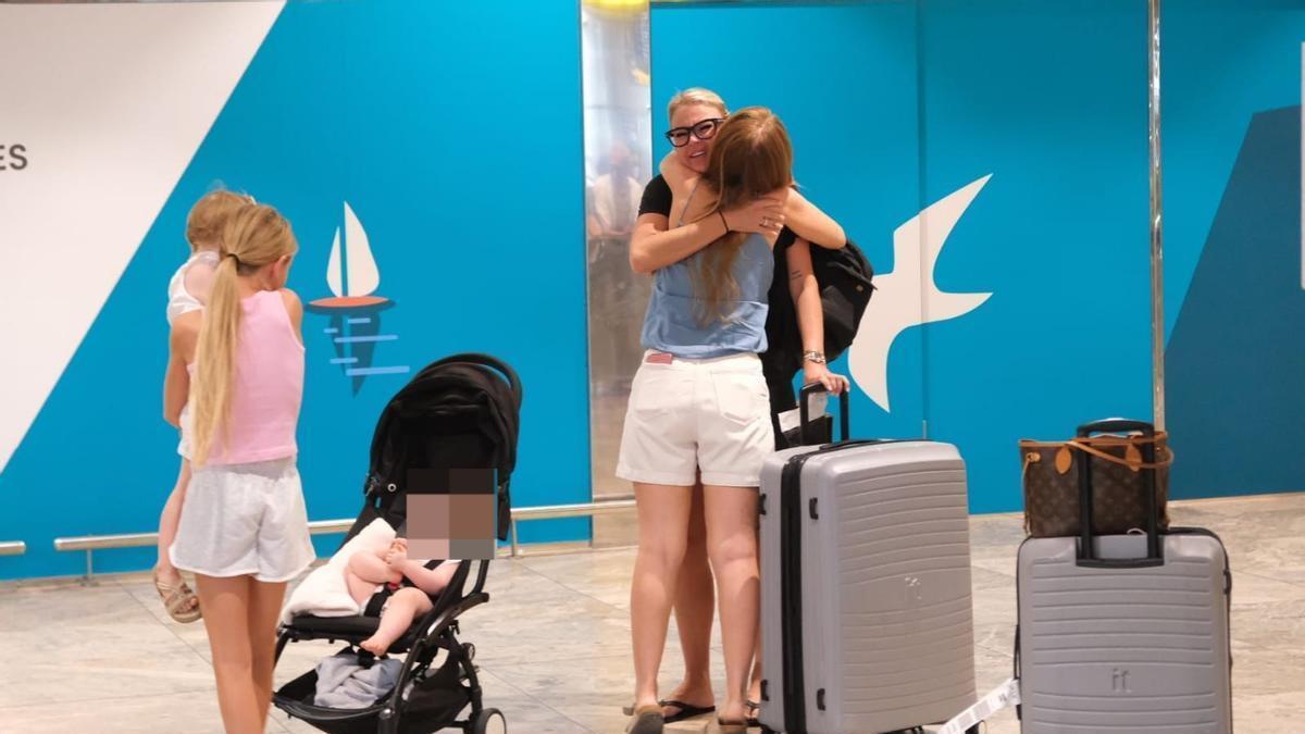 Una familia se abraza en el vestíbulo del aeropuerto.