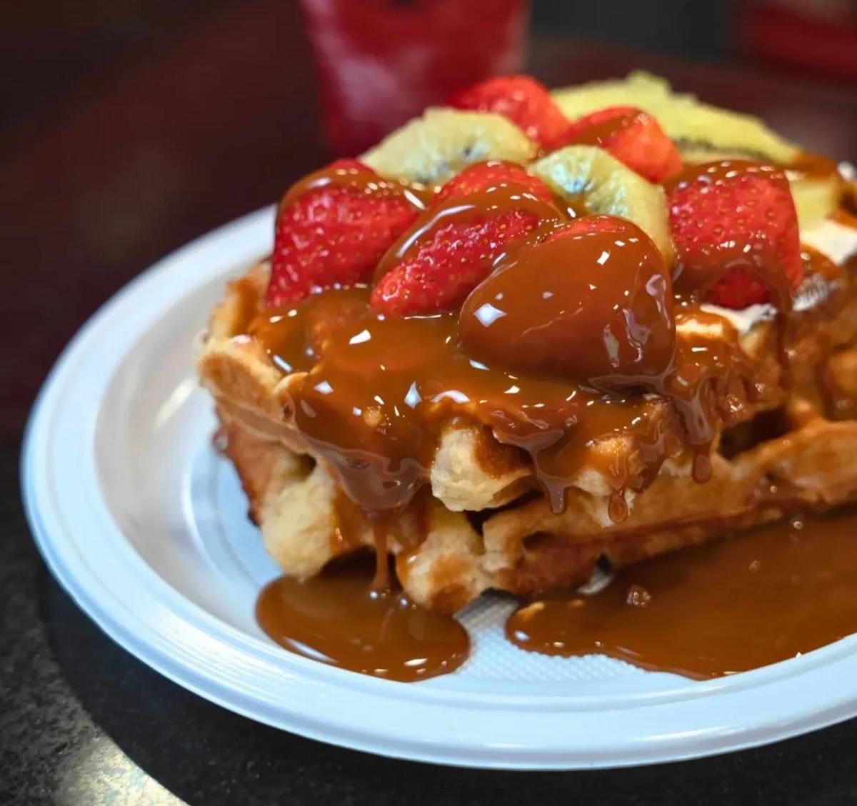 Unos gofres cubiertos por chocolate y frutas