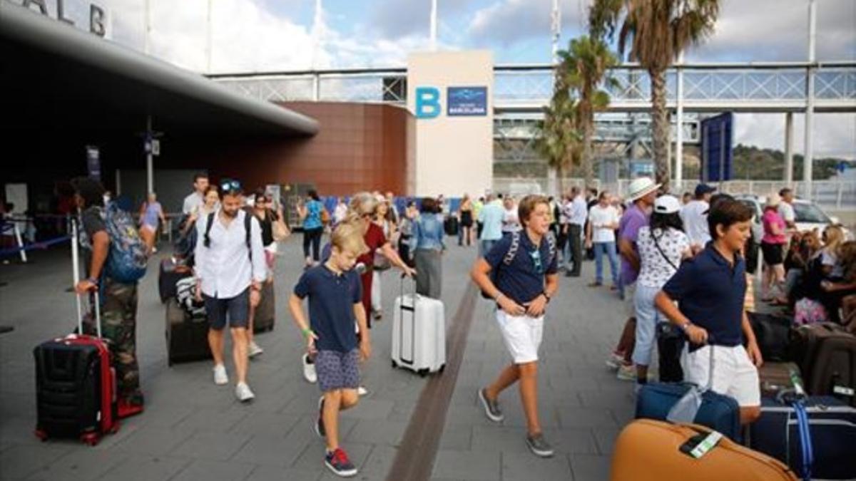 Los pasajeros recogen el equipaje tras el desembarco final.