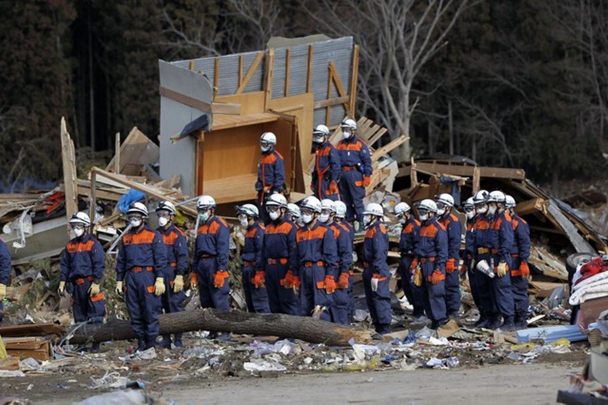 Membres d’un equip de rescat guarden un minut de silenci per les víctimes del terratrèmol, aquest divendres, a Rikuzentakata, a la prefectura d’Iwate. Membres d’un equip de rescat guarden un minut de silenci per les víctimes del terratrèmol, aquest divendres, a Rikuzentakata, a la prefectura d’Iwate.