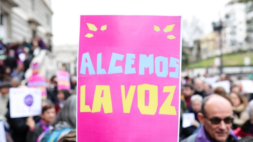 Participante en la concentración de la plataforma Revuelta de Mujeres en la Iglesia junto a la catedral de la Almudena lleva un cartel que dice 'Alcemos la voz', en Madrid (España) a 1 de marzo de 2020.