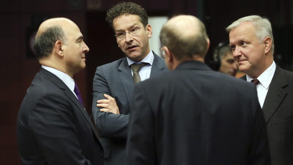 El ministro francés de Finanzas, Pierre Moscovici (izquierda), conversa con el presidente del Eurogrupo, Jeroen Dijsselbloem, y el comisario Olli Rehn, antes del inicio de la reunión de ministros de Finanzas de la UE, este viernes.