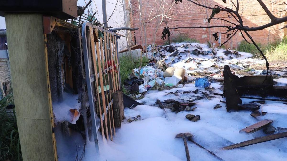 Enseres, basura y maleza cubiertos por la espuma que han empleado los bomberos para apagar el incendio en un solar de la calle Frías, en la zona de San Pedro, en el casco histórico de Córdoba.