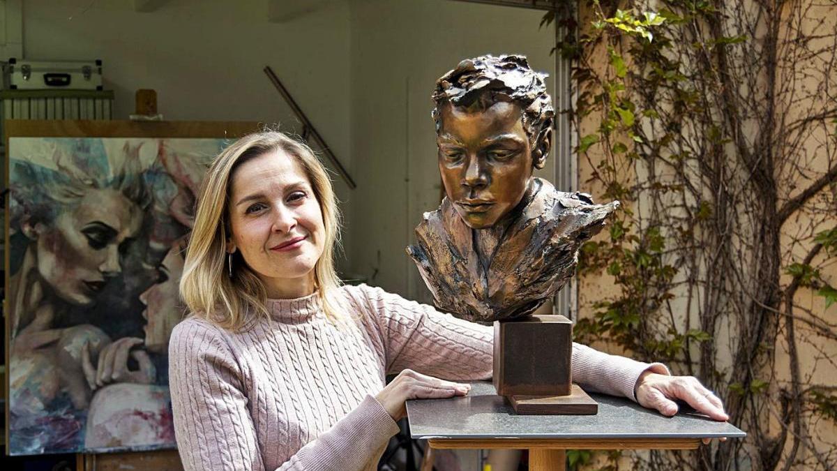 Esther Martínez, al taller de Figueres, mostra una escultura. Al fons una de les darreres pintures