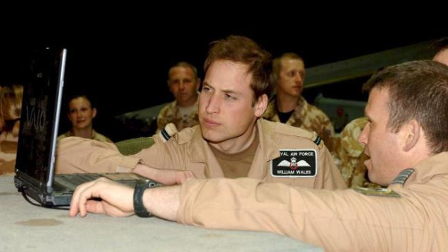 El heredero al trono británico, el príncipe Guillermo (izq), mira en un ordenador portátil imágenes captadas por el avión Harrier GR7A junto al comandante de las fuerzas aéreas reales Andy Lewis durante su visita &quot;secreta&quot; a las tropas británicas que se encuentran en Afganistán, más concretamente en la base aérea de Kandahar, el pasado lunes 28 de abril, durante la fase final de su entrenamiento en este cuerpo militar. El joven de 25 años recibió sus alas de piloto a principios de este mes y llevó durante un tramo un avión de transporte militar desde el Reino Unido a Kandahar.