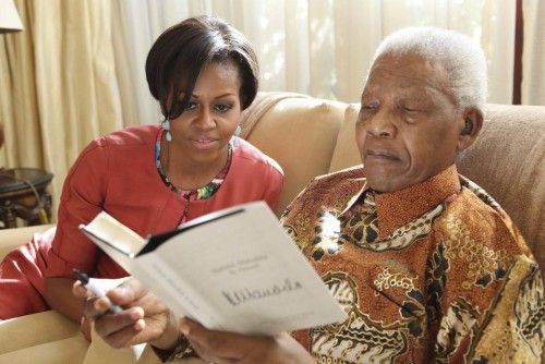 U.S. first lady Michelle Obama and former South African President Nelson Mandela view his newest book titled "Nelson Mandela by Himself" at his home in Johannesburg