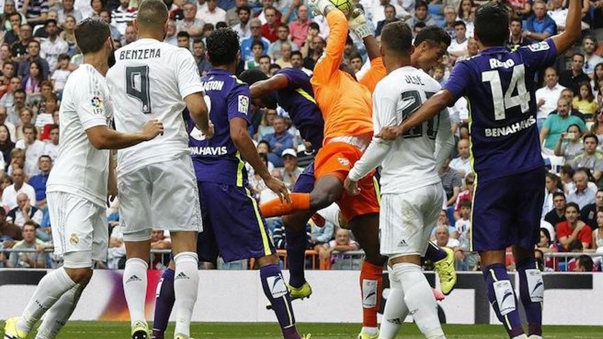El portero camerunés del Málaga, Carlos Kameni, atrapa la pelota ante los delanteros del Real Madrid en el partido de la sexta jornada de liga en Primera División, en el estadio Santiago Bernabéu.