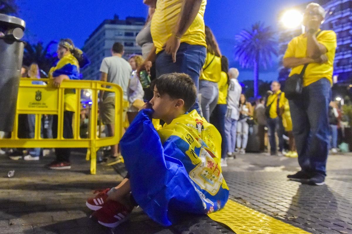 Un niño con la bandera a la espalda nervioso por el partido