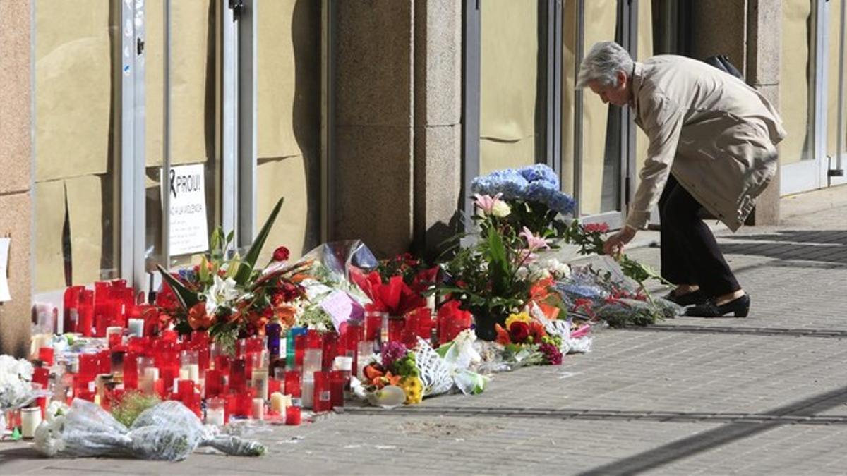 Una mujer deposita flores a las puertas del IES Joan Fuster por el profesor fallecido.