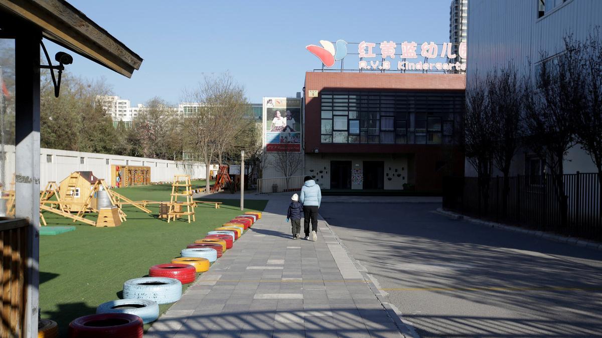 Child walks with a parent at the kindergarten run by pre-school operator RYB Education Inc