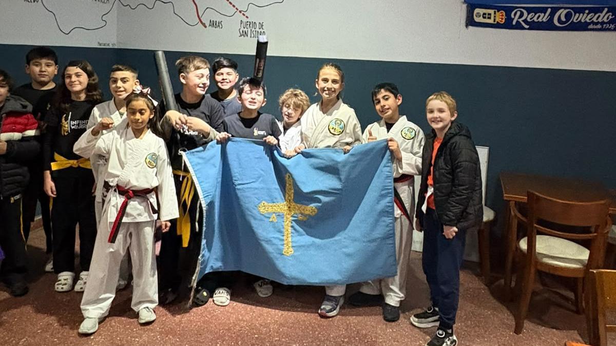 Un grupo de niños del Centro Asturiano de Lanús (Argentina) con la bandera de Asturias que guardan como oro en paño.