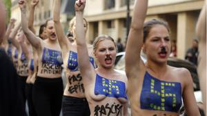 Les activistes desfilen pels carrers de París amb esvàstiques i la bandera de la UE pintades al pit.