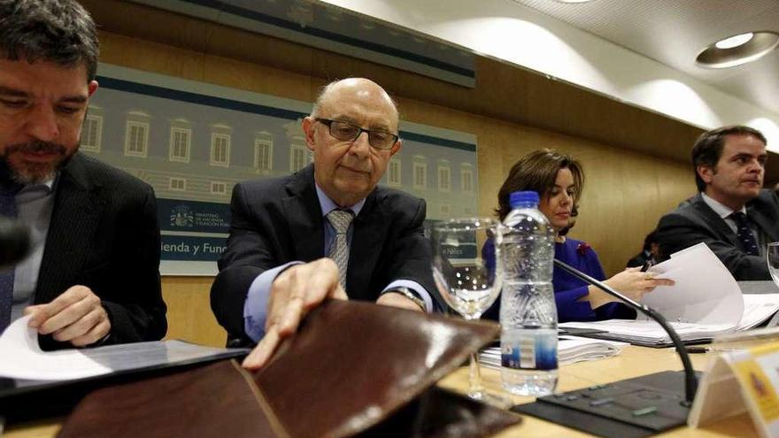 El ministro Cristóbal Montoro y la vicepresidenta, Soraya Sáenz de Santamaría, al comienzo de la reunión del Consejo de Política Fiscal y Financiera. // Efe