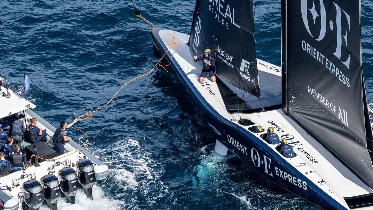 El barco de Orient Express Racing Team, asistido por su equipo antes de que se anulara las última jornada de la 'round robin' de la Louis Vuitton Cup.