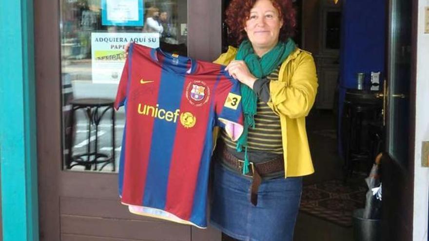 Mai Gutiérrez, con la camiseta de Iniesta a la entrada de su local en Cangas de Onís.