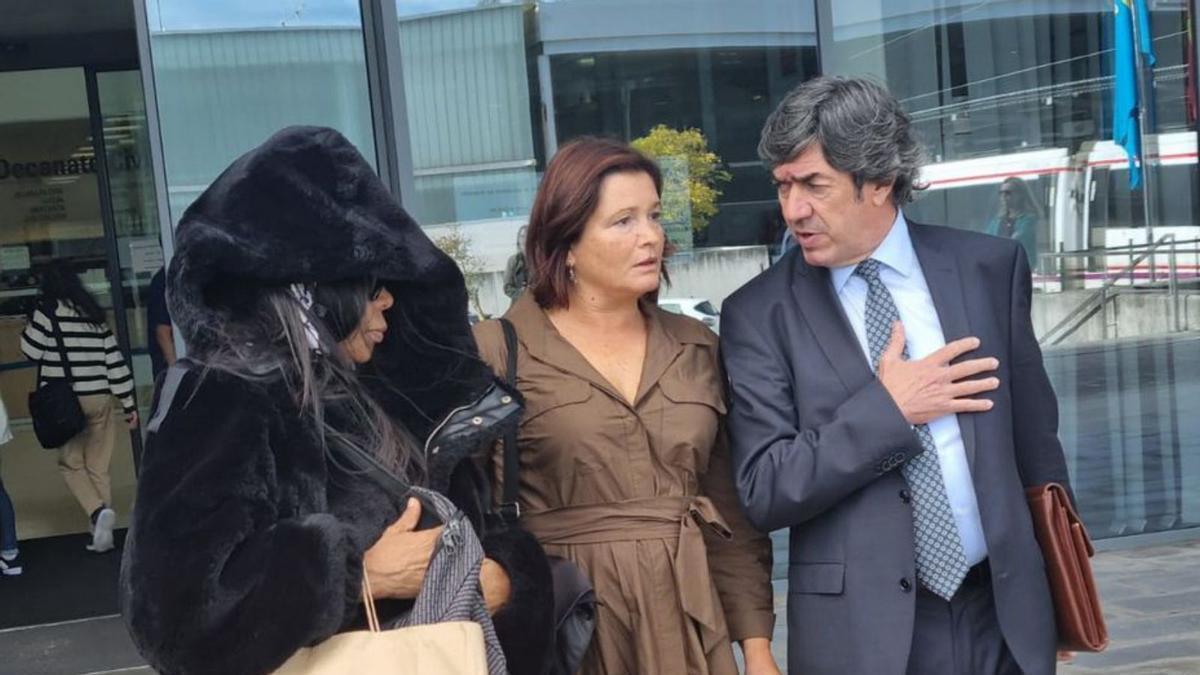 La acusada, a la izquierda, saliendo de los Juzgados junto a su defensa.